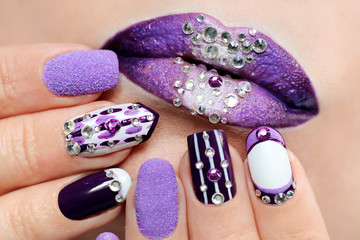 Conception d& 39 ongles violets et blancs sur différentes longueurs et formes d& 39 ongles. Nail art créatif. Maquillage des lèvres avec strass.