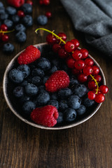 Ripe fresh blueberry, raspberry and red currant on wooden rustic table