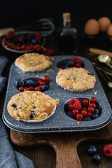 streusel muffins with blueberry, raspberry and red currant on rustic wooden table