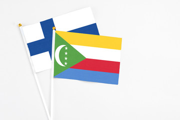 Comoros and Finland stick flags on white background. High quality fabric, miniature national flag. Peaceful global concept.White floor for copy space.