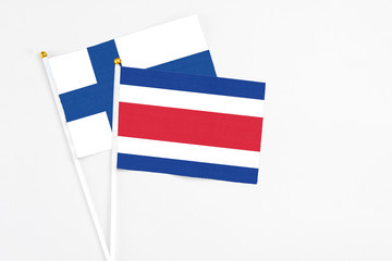 Costa Rica and Finland stick flags on white background. High quality fabric, miniature national flag. Peaceful global concept.White floor for copy space.