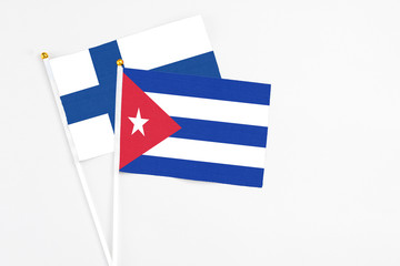 Cuba and Finland stick flags on white background. High quality fabric, miniature national flag. Peaceful global concept.White floor for copy space.