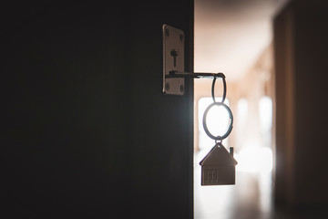 A key in a lock with house icon. process of opening the front door to the apartment.