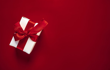 one gift box on a red background. Top view with copy space.