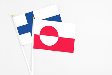 Greenland and Finland stick flags on white background. High quality fabric, miniature national flag. Peaceful global concept.White floor for copy space.