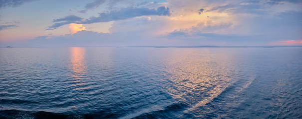 Panorama with the sun penetrates the clouds and the light reflects in the sea