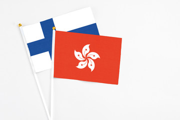 Hong Kong and Finland stick flags on white background. High quality fabric, miniature national flag. Peaceful global concept.White floor for copy space.