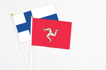 Isle Of Man and Finland stick flags on white background. High quality fabric, miniature national flag. Peaceful global concept.White floor for copy space.
