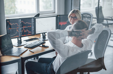 Talking to each other. Two stockbrokers in formal clothes have a break in the office