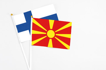 Macedonia and Finland stick flags on white background. High quality fabric, miniature national flag. Peaceful global concept.White floor for copy space.