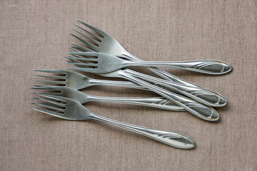 Metal forks on brown textile background