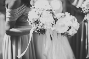 Bride with bridesmaids holding wonderful luxury wedding bouquet of different flowers on the wedding...