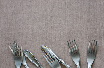 Metal forks on brown textile background