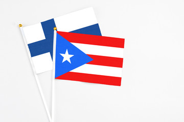 Puerto Rico and Finland stick flags on white background. High quality fabric, miniature national flag. Peaceful global concept.White floor for copy space.