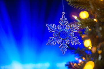 Fototapeta na wymiar Christmas toy on the Christmas tree, on dark blue bokeh background,. Horizontal frame