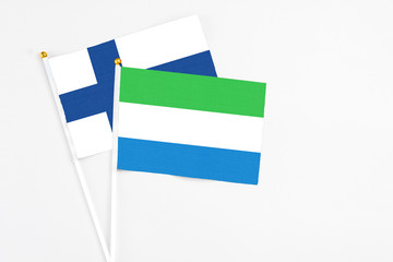 Sierra Leone and Finland stick flags on white background. High quality fabric, miniature national flag. Peaceful global concept.White floor for copy space.