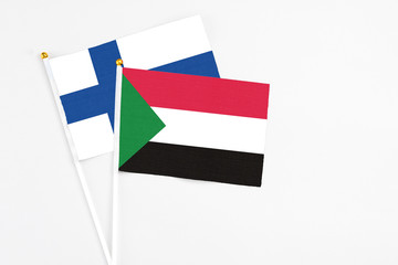 Sudan and Finland stick flags on white background. High quality fabric, miniature national flag. Peaceful global concept.White floor for copy space.