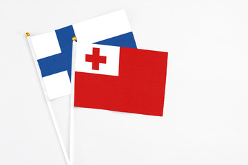 Tonga and Finland stick flags on white background. High quality fabric, miniature national flag. Peaceful global concept.White floor for copy space.
