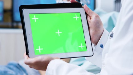 Doctor holding tablet with green screen in a clinic for brain research
