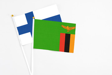 Zambia and Finland stick flags on white background. High quality fabric, miniature national flag. Peaceful global concept.White floor for copy space.