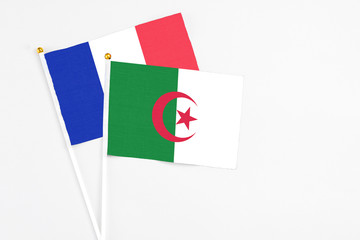 Algeria and France stick flags on white background. High quality fabric, miniature national flag. Peaceful global concept.White floor for copy space.