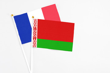 Belarus and France stick flags on white background. High quality fabric, miniature national flag. Peaceful global concept.White floor for copy space.