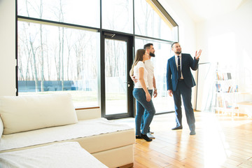 real estate agent shows a young couple a new home. family buys housing