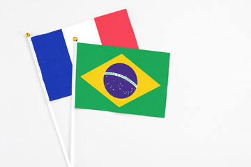 Brazil and France stick flags on white background. High quality fabric, miniature national flag. Peaceful global concept.White floor for copy space.