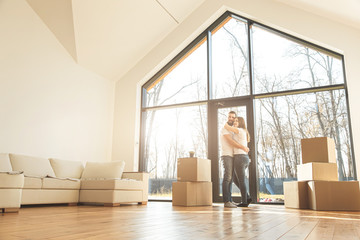 young couple moves to a new home. the family carries boxes of things after buying a home.