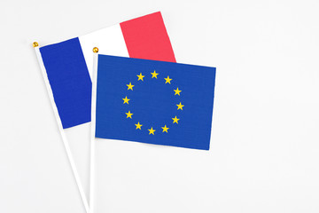 European Union and France stick flags on white background. High quality fabric, miniature national flag. Peaceful global concept.White floor for copy space.