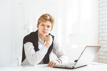 Young businessman working in the office at the laptop
