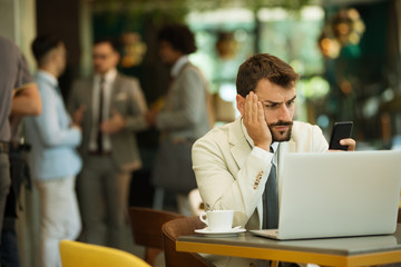 Handsome young businessman writes a message on mobile