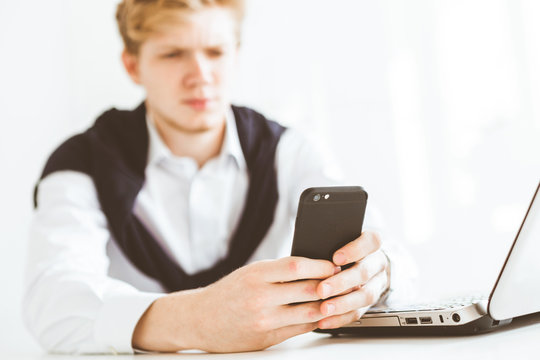 Young businessman working in the office at the laptop