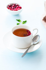 Tea with cranberry on a light blue background.