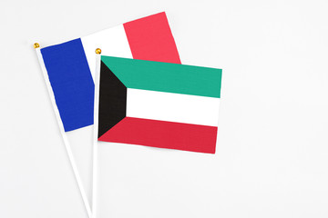 Kuwait and France stick flags on white background. High quality fabric, miniature national flag. Peaceful global concept.White floor for copy space.