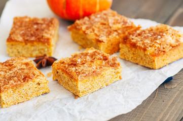Pumpkin cornmeal bars on a wooden background.