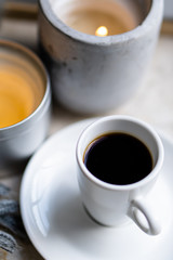 Burning candles, gray blanket and cup of coffee