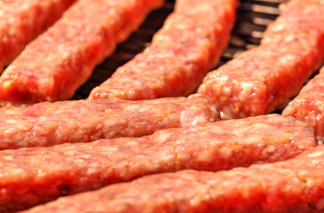 Grilling fresh meat on barbecue close up view