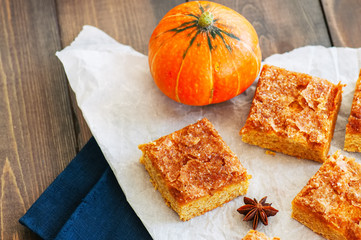 Pumpkin cornmeal bars on a wooden background.