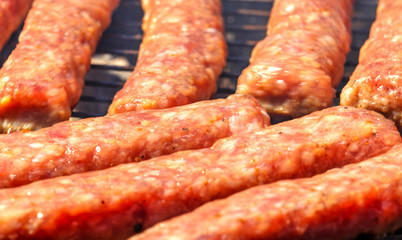 Grilling fresh meat on barbecue close up view