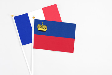 Liechtenstein and France stick flags on white background. High quality fabric, miniature national flag. Peaceful global concept.White floor for copy space.