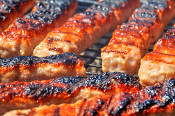 Grilling fresh meat on barbecue close up view