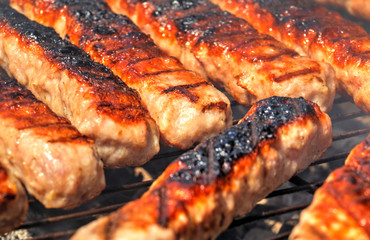 Grilling fresh meat on barbecue close up view