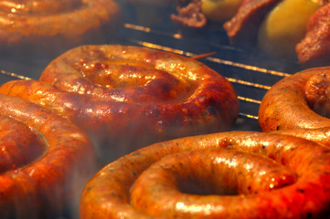 Grilling delicious sausages on barbecue close up view
