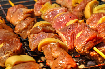 Grilling fresh meat and mushrooms on barbecue close up view