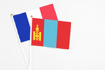 Fototapeta premium Mongolia and France stick flags on white background. High quality fabric, miniature national flag. Peaceful global concept.White floor for copy space.