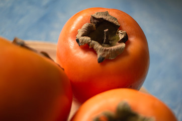 Plate of fresh and ripe persimmons. Top view and copy space.