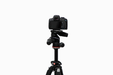 Photo camera with lens on the tripod. Studio shot on white isolate background