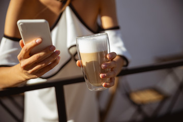 Woman having her morning coffee and texting