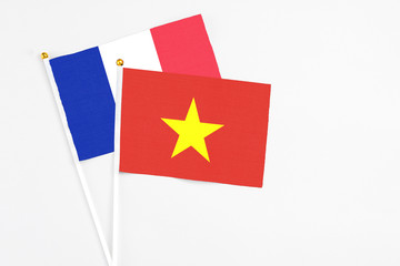Vietnam and France stick flags on white background. High quality fabric, miniature national flag. Peaceful global concept.White floor for copy space.
